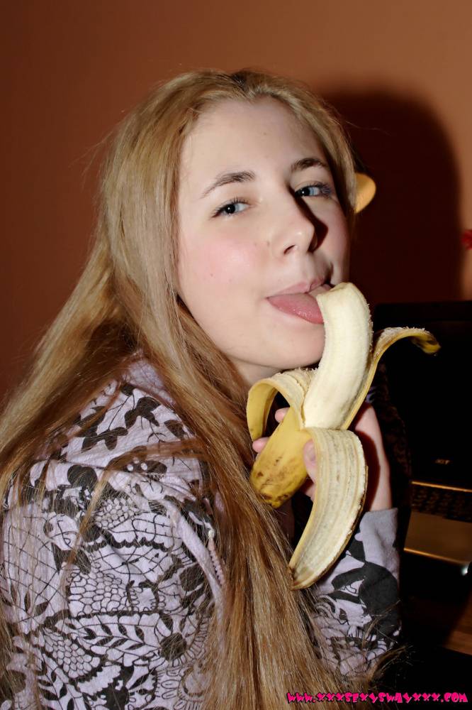 Young looking girl with long hair eats a banana before stripping to her socks - #13
