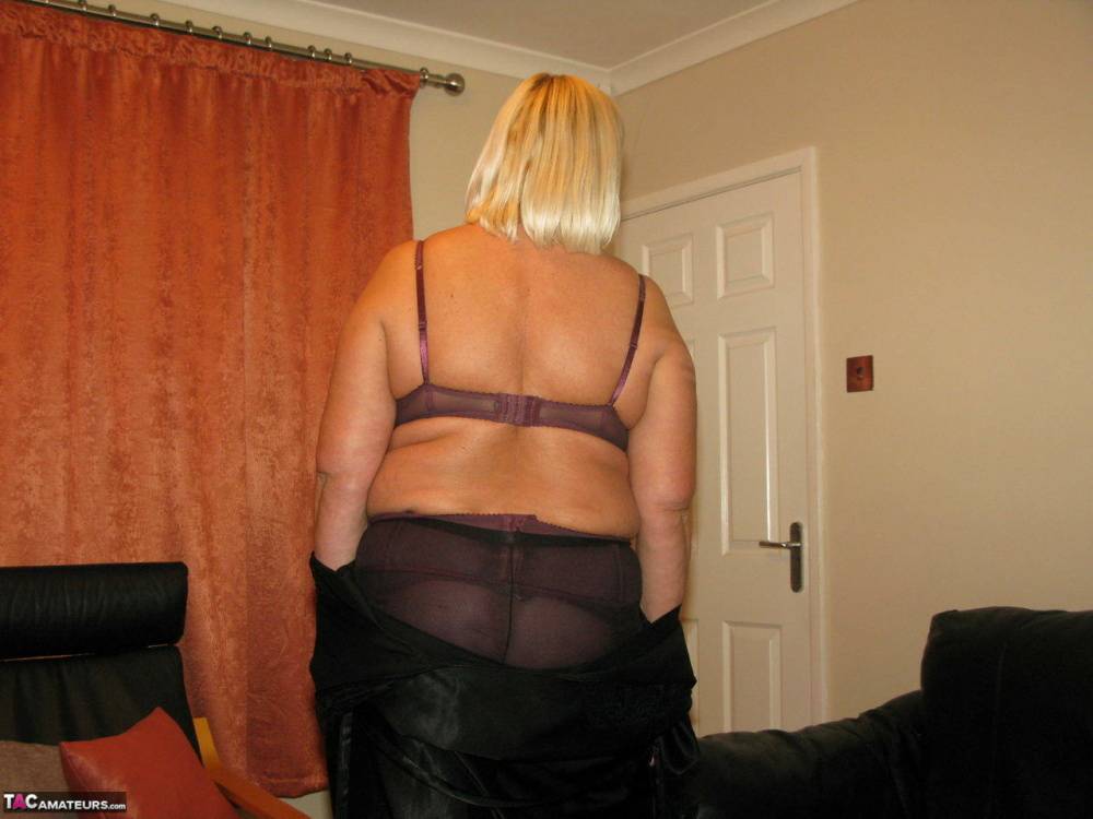 Older blonde BBW Chrissy Uk models lingerie & pantyhose on a leather loveseat - #12