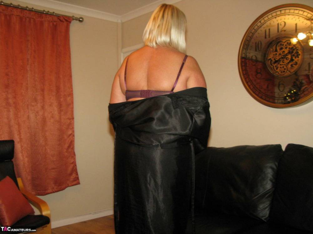 Older blonde BBW Chrissy Uk models lingerie & pantyhose on a leather loveseat - #15