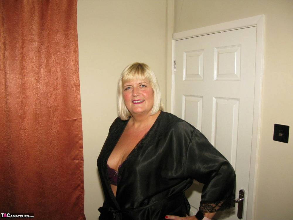 Older blonde BBW Chrissy Uk models lingerie & pantyhose on a leather loveseat - #5