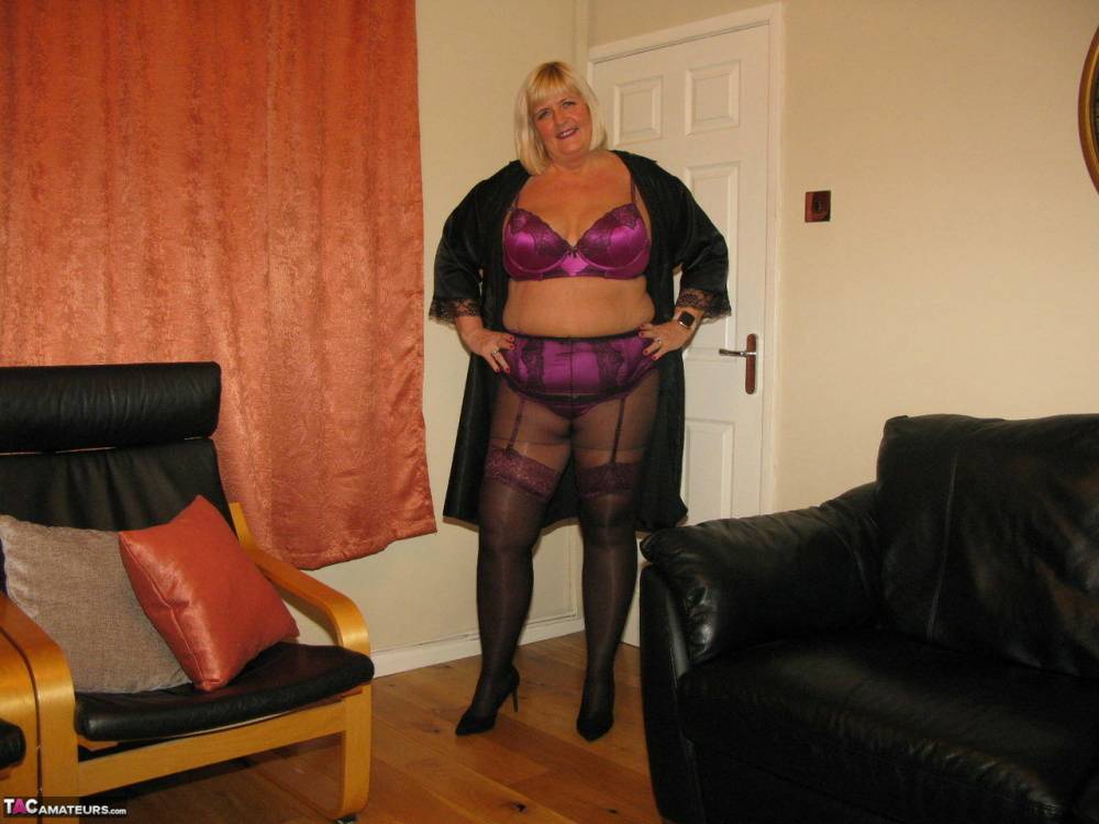 Older blonde BBW Chrissy Uk models lingerie & pantyhose on a leather loveseat - #14