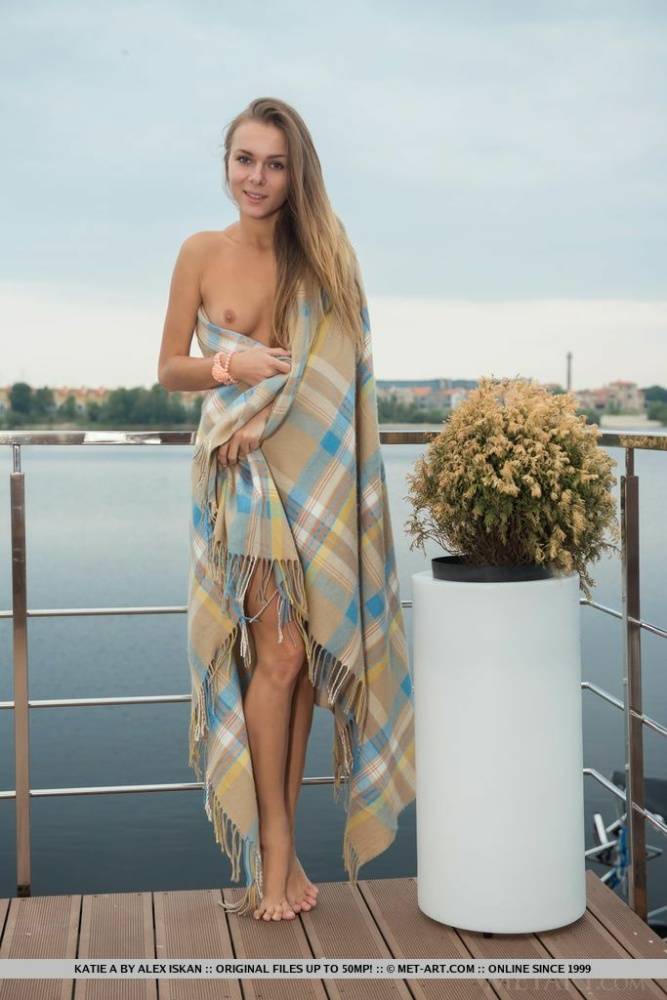 Nice teen Katie A shows off her flexibility while naked on a riverside patio - #2