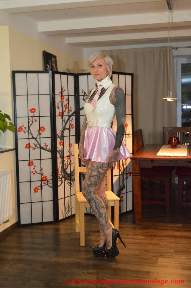 Tattooed platinum blonde Miss Francine models a raincoat over a latex dress - #13