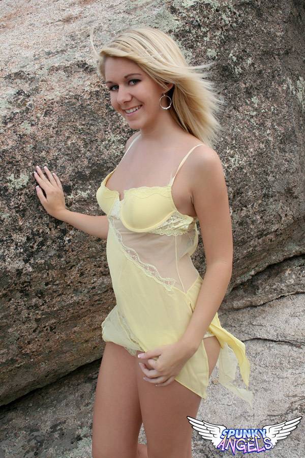Young blonde Ashlee proudly shows her smooth pussy on a rock inside a park - #10
