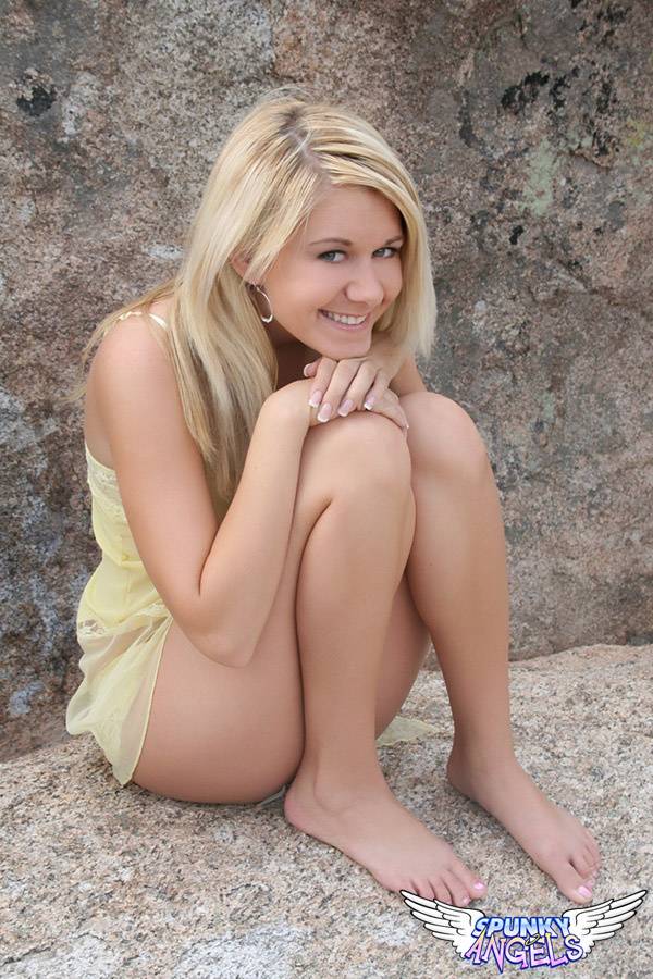 Young blonde Ashlee proudly shows her smooth pussy on a rock inside a park - #9