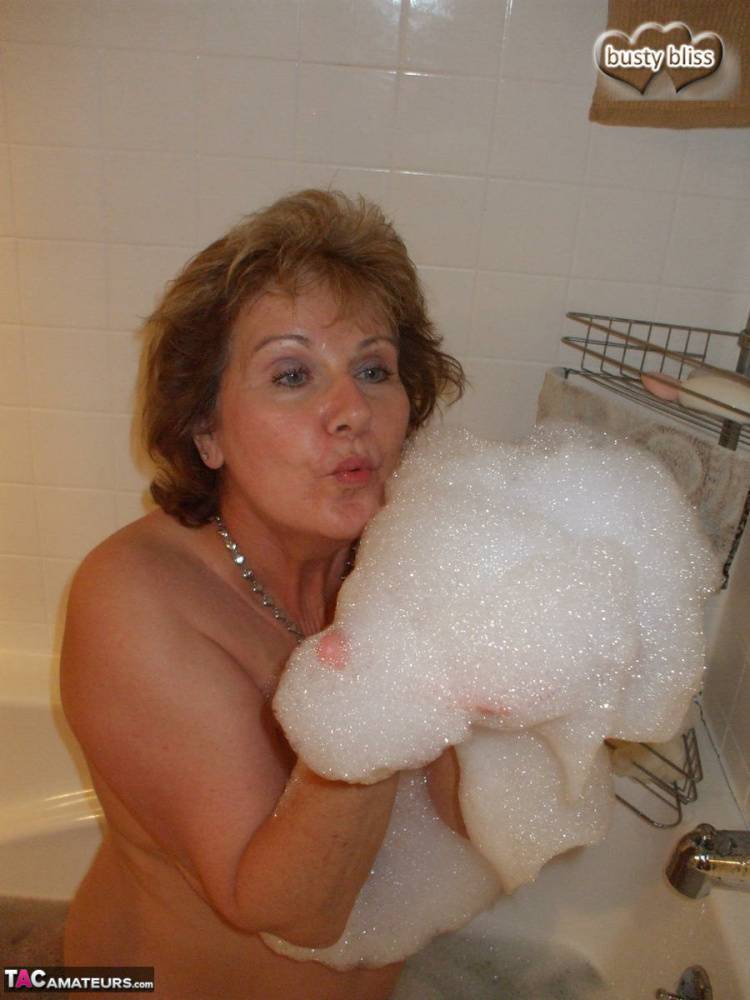 Older amateur Busty Bliss licks her lips during a playful bubble bath - #10