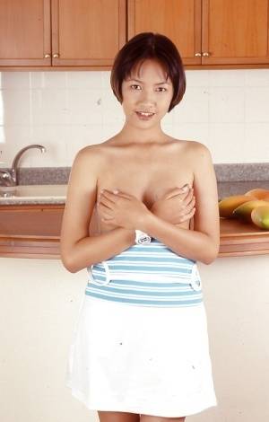 Clothed Asian with tiny tits is posing in the kitchen with spread legs - #main