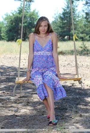 Long legged teen Mirabella doffs a dress to pose nude on a swing under a tree - #main