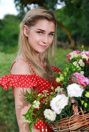Young blonde Christine Cardo gets naked in a hilly field while picking flowers - #main