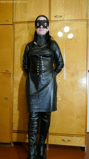 Collared solo woman models leather clothing while wearing a mask - #main