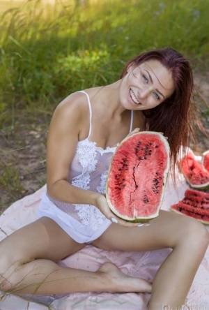 Sweet young girl gets naked while eating a watermelon under a tree - #main