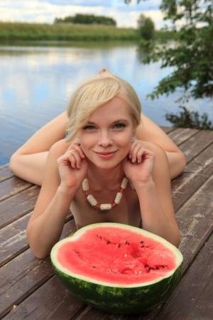 Beautiful blonde Feeona eats a watermelon while posing naked on lakeside dock - #main