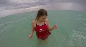 Teen babe Kimber Lee flashing large natural tits in the ocean on clubgf.com