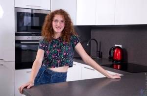 Teen solo girl Foxy Lee sports curly red hair while getting naked in a kitchen on clubgf.com