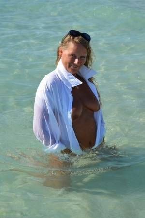 Blonde amateur Sweet Susi steps into the ocean while naked in a white shirt on clubgf.com