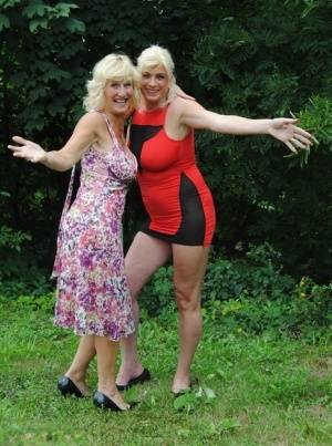Mature lesbian Dimonty and GF cover their naked bodies in see thru raincoats on clubgf.com