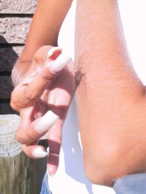 Amateur model Lori Anderson tugs on her arm hairs with manicured nails on clubgf.com