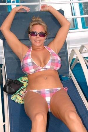 Hugely busty Amber Lynn Bach doffs her bikini to spread her legs wide nude on clubgf.com