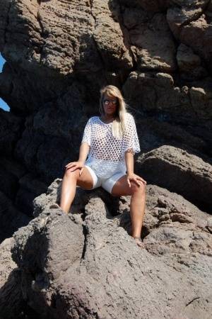 Blonde amateur Sweet Susi exposes her tits and ass on a rocks by the sea on clubgf.com