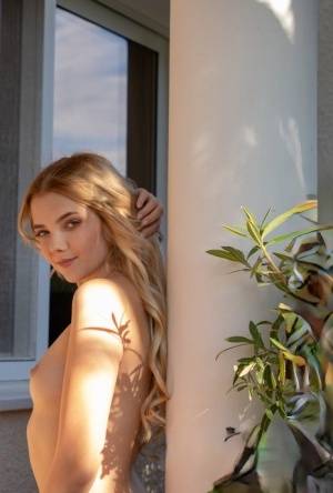 Young blonde Chanel Fenn shows her sexy ass while getting naked in a garden on clubgf.com