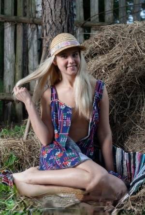 Young blonde Agnes H doffs a dress to get naked on weathered straw in a yard on clubgf.com