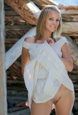 Young blonde Ilona D gets naked in a rustic setting with her boots on on clubgf.com