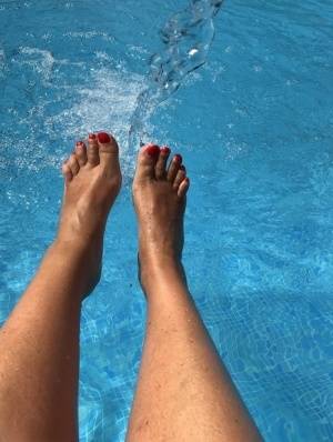 Mature woman Sweet Susi dips her painted toenails into a swimming pool on clubgf.com