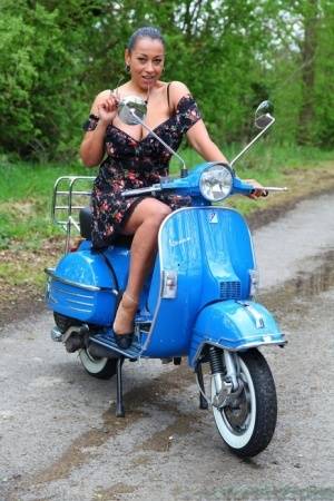 Mature lady Danica Collins exposes large tits and twat on a scooter on clubgf.com