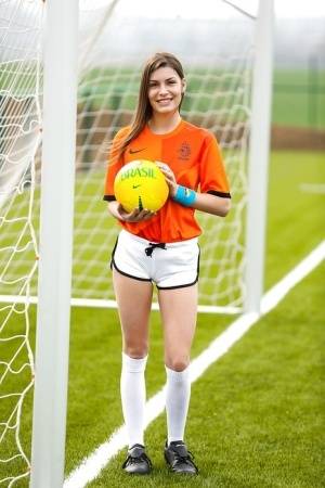 Lilly P is undressing her soccer uniform while on the field with a ball on clubgf.com