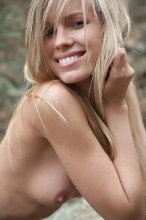 Smiling MILF Marketa shows off her nude body atop a rock outdoors on clubgf.com