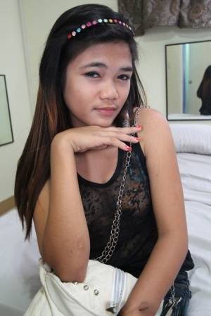 Young Filipina girl with a saucy look stands naked after undressing on clubgf.com